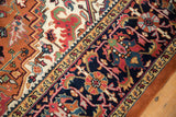 Intact rust selvage and patterned navy blue border of the vintage Heriz rug.