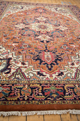 White fringe and intricate floral navy border of a vintage Indian Heriz carpet.
