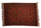 Vintage Afghani Bokhara rug with repeating gul medallions in chestnut rust, charcoal, and yellow.