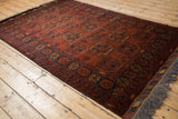 Vintage Afghani Bokhara rug with a lustrous, rust-colored pile and repeating gul medallions.