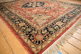 Vintage Pakistani Serapi rug corner with charcoal navy border, copper vinery, and beige fringe.