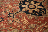Elaborate floral vinery and contrasting navy patterns on a terracotta vintage Serapi rug.