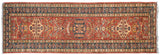 Pakistani Caucasian design rug runner with center medallions on a cherry red field and indigo borders.