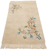 Pastel floral vinery in blush, seafoam mint, and indigo on an ivory Art Deco rug with fringe.