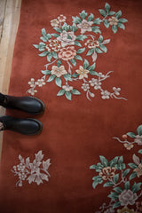 Plush copper Art Deco rug with celadon and mauve floral sprays.