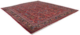 Angled perspective of a vintage Mahal carpet, showcasing its gem-toned floral pattern and dark navy border.