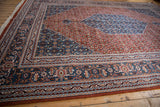 Intricate floral and geometric borders in denim blue, rust, and sand on the vintage Indian Bijar carpet.