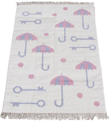 Playful pink polka dots, blue umbrellas, and skeleton key motifs on a vintage Indian Kilim.