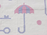 Playful pink and blue umbrella, key, polka dot motifs on an ivory hand-woven Indian Kilim.
