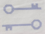 Hand-woven Kilim rug close-up with pictorial pale blue slate skeleton key motifs.