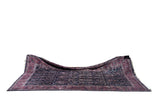 Draped perspective of a collector Sarouk carpet highlighting its saturated indigo and aubergine hues.