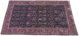 Fine vintage Sarouk carpet from a perspective angle, showing its grand scale and deep indigo floral field.