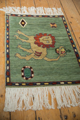 Armenian pictorial rug corner, celadon green field, geometric motif, banded border, white fringe.