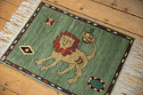 Armenian rug corner: celadon green field, geometric floral, banded cartouche border, and white fringe.