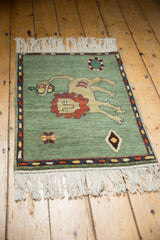 Armenian pictorial lion with terracotta mane, pomegranate, and geometric florals on celadon field.