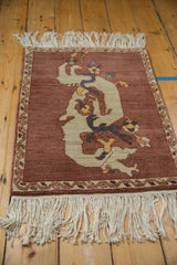 Ivory cloud-band dragon motif on abrashed aubergine field with vine border.