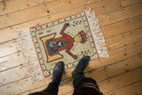 Vintage pictorial Armenian rug with ivory field and central red, yellow, blue figural.