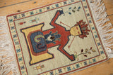 Close-up detail: Ivory field with figural personage and plant motifs on Armenian rug.