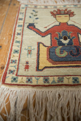 Soft ivory fringe and narrow border with simplistic figural and plant motifs.