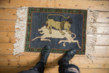 Pictorial Armenian hunting scene with dark denim blue field, green border, and ivory fringe.