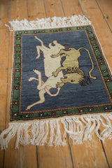 Pictorial Armenian rug: lion feasting on prey against a dark denim blue field.