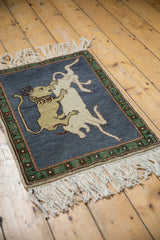 Pictorial lion and ivory prey detail on dark blue, with green geometric border.
