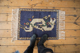 A sprawling ivory dragon with floral accents on an abrashed cobalt blue vintage Armenian rug mat.