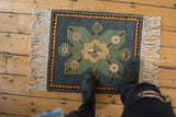 A vintage Yerevan square rug with a central starburst medallion, viewed from above for scale.