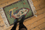 Vintage pictorial Armenian rug corner showing emerald green field, peacock, and ornate boteh border.