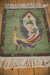 Vintage Armenian rug corner showing abrashed pale emerald green field and colorful boteh border.