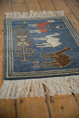 Reciprocating chevron border and primitive floral and herdsman motifs on denim blue.