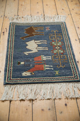 Close-up of vintage pictorial Armenian rug corner, with ivory fringe and chevron border.