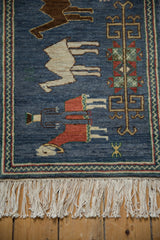 Natural ivory fringe and vibrant chevron border on the denim blue pictorial Armenian rug.
