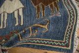 Denim blue pile with chevron border, showing ram's horn buds and ivory fringe.
