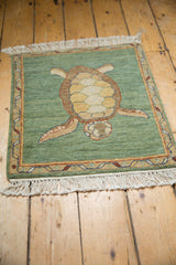 Hand-knotted pile texture, ivory fringe, and colorful vine border on the green rug.