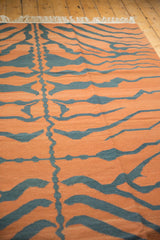 Handwoven vintage tiger kilim carpet featuring pale rust and oxidized dark blue stripes.