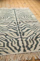 Vintage modern Zebra Kilim rug showing textured ivory and charcoal stripes, with fringed end.