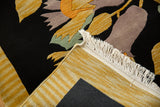 Plush black pile with Art Deco floral details, white fringe, and striped hand-knotted backing.