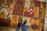 Geometric patchwork Kilim rug featuring brick red, saffron, charcoal and cross-stitch seams.