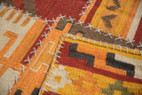 Textural view of geometric patchwork kilim panels with raised cross-hatch stitches.