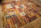 Warm-toned geometric patchwork kilim showing finned floral guls and cross-hatch stitching.