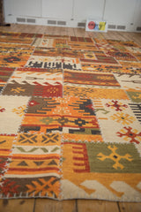 Flatweave patchwork kilim with geometric patterns, raised cross-hatch stitching, and warm palette.