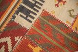 Raised cross-hatch stitches on brick red, ivory, and brown geometric patchwork kilim.
