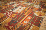 Warm-toned geometric patchwork Kilim rug, showing varied panels and prominent cross-hatch stitching.