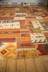 Geometric patchwork Kilim rug detail with primitive motifs and raised cross-hatch stitches.