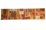 Patchwork Kilim runner rug with geometric panels in warm shades of red, orange, yellow, and brown.