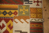 Raised cross-hatch stitches joining geometric panels in warm tones on a patchwork kilim.