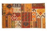 Warm geometric patchwork Kilim rug with primitive motifs, finned floral guls, and cross-stitch seams.