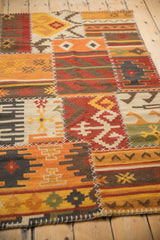 Textured white cross-stitch seams join multi-color geometric panels of this patchwork Kilim.
