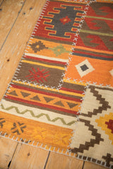 Close-up of patchwork kilim panel with visible white cross-hatch stitching and geometric motifs.